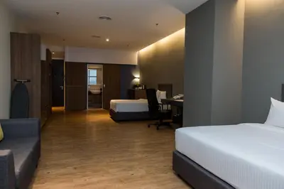 a hotel room with two beds and a desk at Imperial Regency Suites & Petaling Jaya in Kuala Lumpur