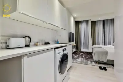 a white kitchen with a washing machine in a room at Expressionz Suites By iHost Global in Kuala Lumpur