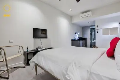 a white bedroom with a bed and a desk at Expressionz Suites By iHost Global in Kuala Lumpur