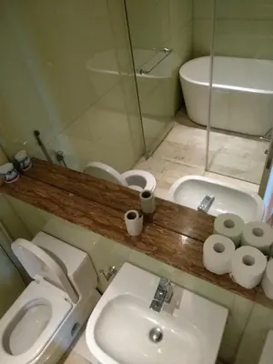 a small bathroom with a toilet and a sink at Soho Suites KL City Centre in Kuala Lumpur