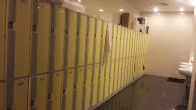a row of yellow stalls in a public bathroom at Soho Suites KL City Centre in Kuala Lumpur