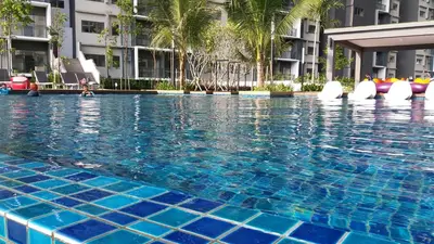 a large swimming pool with blue tiles in front of a building at Adna Homestay Wangsa Maju in Kuala Lumpur