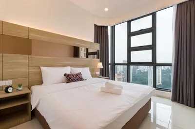 a bedroom with a large white bed with a large window at Robertson Suites by Airhost in Kuala Lumpur