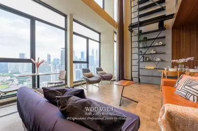 a living room with a couch and large windows at Expressionz KLCC by Wodages in Kuala Lumpur
