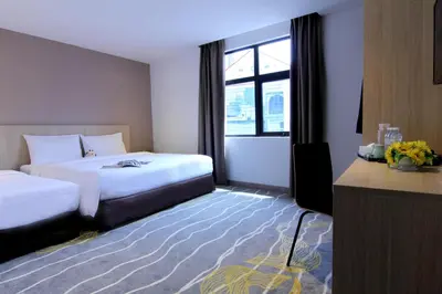 a hotel room with two beds and a window at Pacific Express Hotel Chinatown in Kuala Lumpur