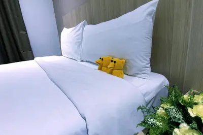 two stuffed animals sitting on top of a bed at Pacific Express Hotel Chinatown in Kuala Lumpur