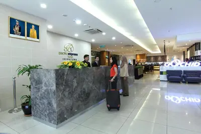 a woman with a suitcase walking through a shopping mall at Pacific Express Hotel Chinatown in Kuala Lumpur