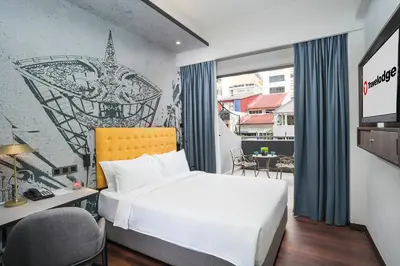 a hotel room with a bed and a desk and a window at Travelodge Kuala Lumpur City Centre in Kuala Lumpur