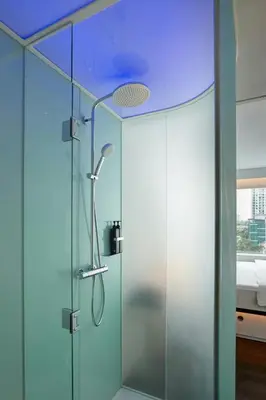 a shower in a bathroom with a blue ceiling at citizenM Kuala Lumpur in Kuala Lumpur