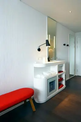 a living room with a red bench and a mirror at citizenM Kuala Lumpur in Kuala Lumpur