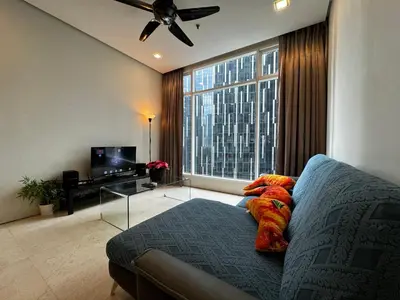 a stuffed animal laying on a couch in a living room at Soho Suites KLCC by Alucard's Cat in Kuala Lumpur