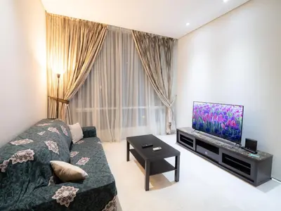 a living room with a couch and a flat screen tv at Soho Suites KLCC by Alucard's Cat in Kuala Lumpur