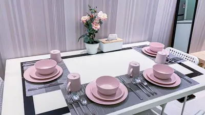 a dining room table with pink dishes on it at Soho Suites KLCC by Alucard's Cat in Kuala Lumpur