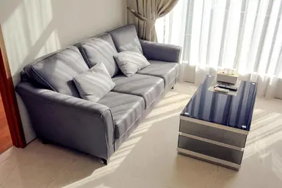 a leather couch in a living room with a table at Soho Suites KLCC by Alucard's Cat in Kuala Lumpur