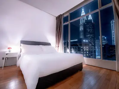 a bedroom with a large white bed and a window at Soho Suites KLCC by Alucard\uff08\u5409\u9686\u5761KLCC Alucard Soho\u5957\u623f\u516c\u5bd3\uff09 in Kuala Lumpur