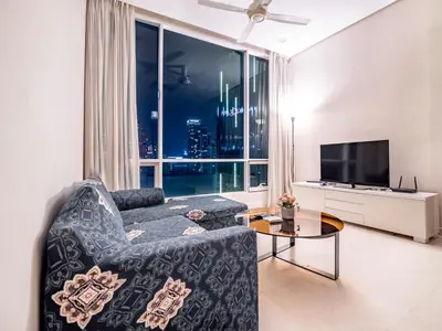 a living room with a couch and a large window at Soho Suites KLCC by Alucard\uff08\u5409\u9686\u5761KLCC Alucard Soho\u5957\u623f\u516c\u5bd3\uff09 in Kuala Lumpur