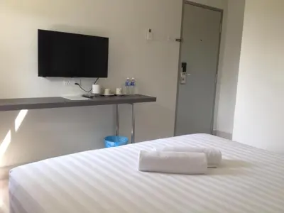 a bedroom with a white bed with a flat screen tv at Festival Boutique Hotel @ Kampung Pandan in Kuala Lumpur
