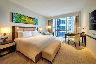 a hotel room with a large bed and a desk at Pavilion Hotel Kuala Lumpur Managed by Banyan Tree in Kuala Lumpur