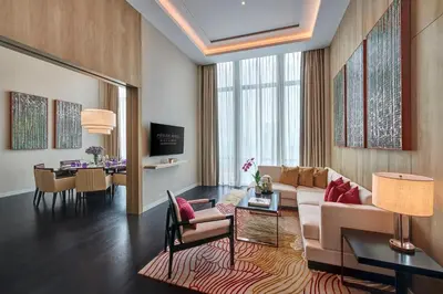a living room with a couch and a dining room at Pavilion Hotel Kuala Lumpur Managed by Banyan Tree in Kuala Lumpur