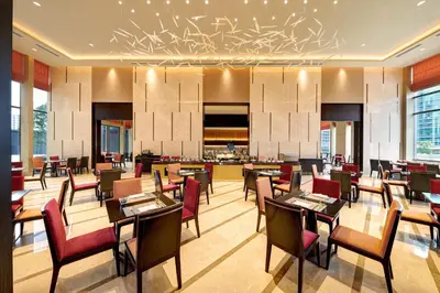 a restaurant with tables and chairs and a bar at Pavilion Hotel Kuala Lumpur Managed by Banyan Tree in Kuala Lumpur