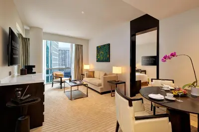 a living room with a room with a couch and a table at Pavilion Hotel Kuala Lumpur Managed by Banyan Tree in Kuala Lumpur