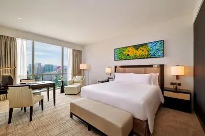 a hotel room with a large bed and a desk at Pavilion Hotel Kuala Lumpur Managed by Banyan Tree in Kuala Lumpur