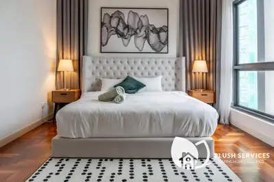a bedroom with a large white bed with two lamps at The Mews KLCC by Plush in Kuala Lumpur