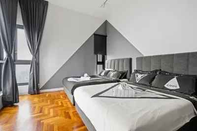a bedroom with two beds and a large window at The Mews KLCC by Plush in Kuala Lumpur