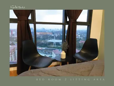 two chairs and a table in front of a window at KL Gateway Mall - Easy Access to KL Sentral & KLCC in Kuala Lumpur