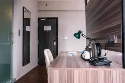 a wooden desk with a phone and a lamp on it at Days Hotel & Suites by Wyndham KL - Chan Sow Lin MRT or LRT in Kuala Lumpur