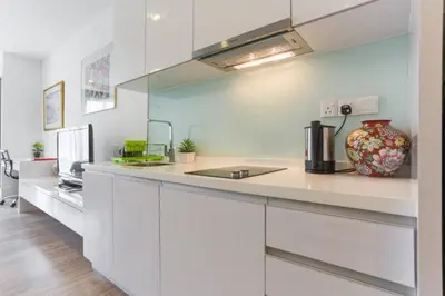 a kitchen with white cabinets and a vase on a counter at Perfect Location@ Heart of KL City Centre next to Metro MRT in Kuala Lumpur