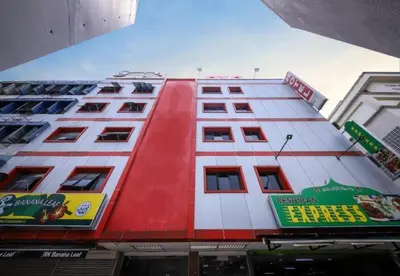 a red and white building with signs on it at Hotel De Grand Orchard in Kuala Lumpur