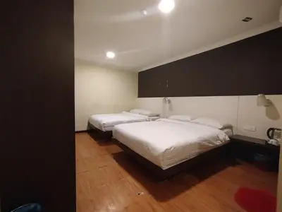 two beds in a hotel room with white sheets at Hotel De Grand Orchard in Kuala Lumpur