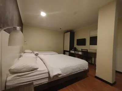 a bedroom with a bed and a table in a room at Hotel De Grand Orchard in Kuala Lumpur