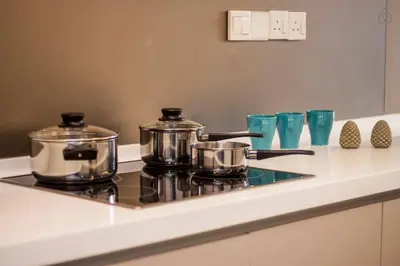 two pots and pans on a stove in a kitchen at Suasana Bukit Ceylon by Plush in Kuala Lumpur