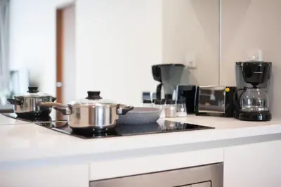 a kitchen with two pots and pans on a stove at Soho Suites KLCC in Kuala Lumpur