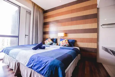 a bedroom with a bed with a striped wall at Maxhome @ D'Majestic Place, KL City Centre in Kuala Lumpur