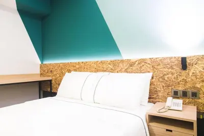 a bedroom with a bed and a desk with a phone at i-Hotel Kuala Lumpur in Kuala Lumpur