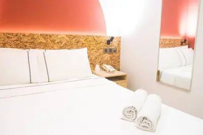 a bedroom with a white bed and a mirror at i-Hotel Kuala Lumpur in Kuala Lumpur