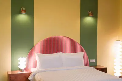 a bedroom with a bed with red and white stripes at The Très Hotel in Kuala Lumpur