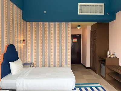 a bedroom with a bed with a blue wall at The Très Hotel in Kuala Lumpur