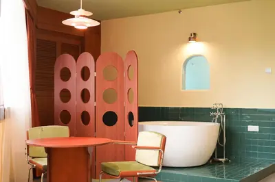 a bathroom with a tub and a table and surfboards at The Très Hotel in Kuala Lumpur
