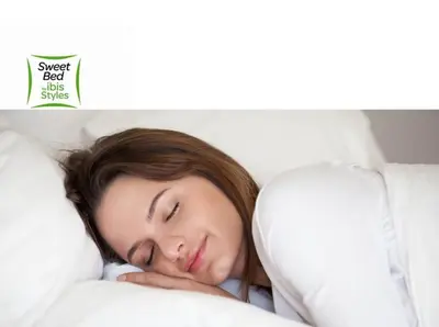 a woman laying in bed with her head on a pillow at Ibis Styles Kuala Lumpur Fraser Business Park in Kuala Lumpur
