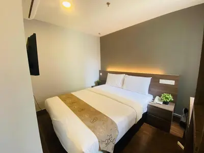 a bedroom with a large white bed and a television at Asia Like Boutique Hotel in Kuala Lumpur