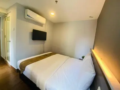 a bedroom with a white bed and a tv at Asia Like Boutique Hotel in Kuala Lumpur