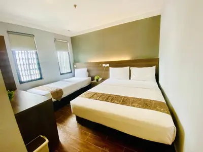 a hotel room with two beds and a desk at Asia Like Boutique Hotel in Kuala Lumpur