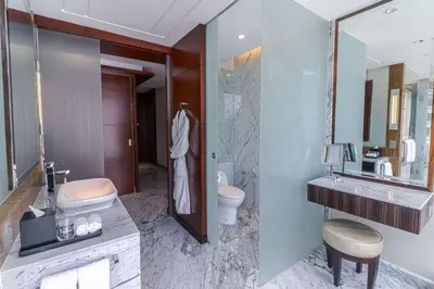 a bathroom with a sink and a toilet and a mirror at Grand Hyatt Kuala Lumpur in Kuala Lumpur
