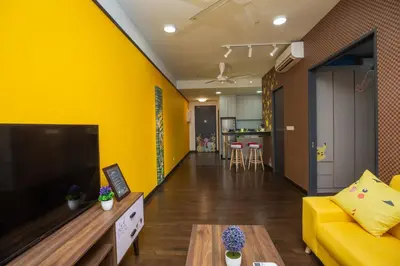 a living room with a yellow wall and a yellow couch at Velocity KL By PSM Luxury Suites in Kuala Lumpur