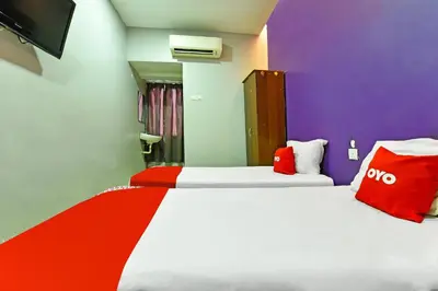 a bedroom with two beds with red and white pillows at Hotel O Elwarda Klcity in Kuala Lumpur