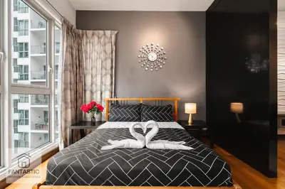 a bedroom with two swans towels on a bed at Regalia Residence by FANTASTIC in Kuala Lumpur